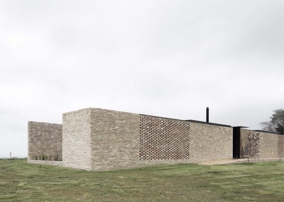 a brick building with a grass field
