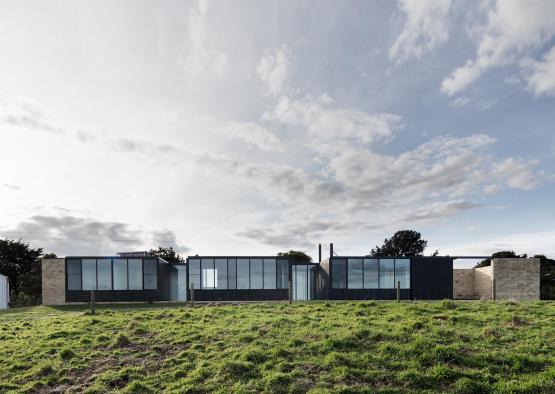 a building with glass walls and a grassy field