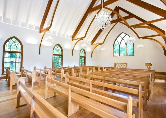 a church with wooden benches and chandeliers