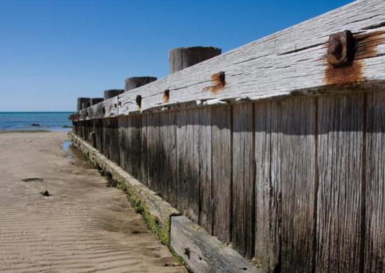 a wooden fence on a beach