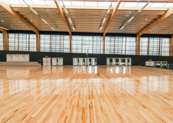 a large indoor gym with a wooden floor
