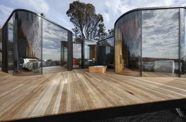 a glass building with a wooden deck