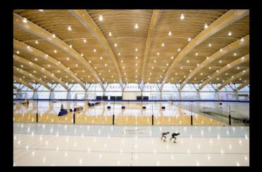 a large indoor ice rink with people skating