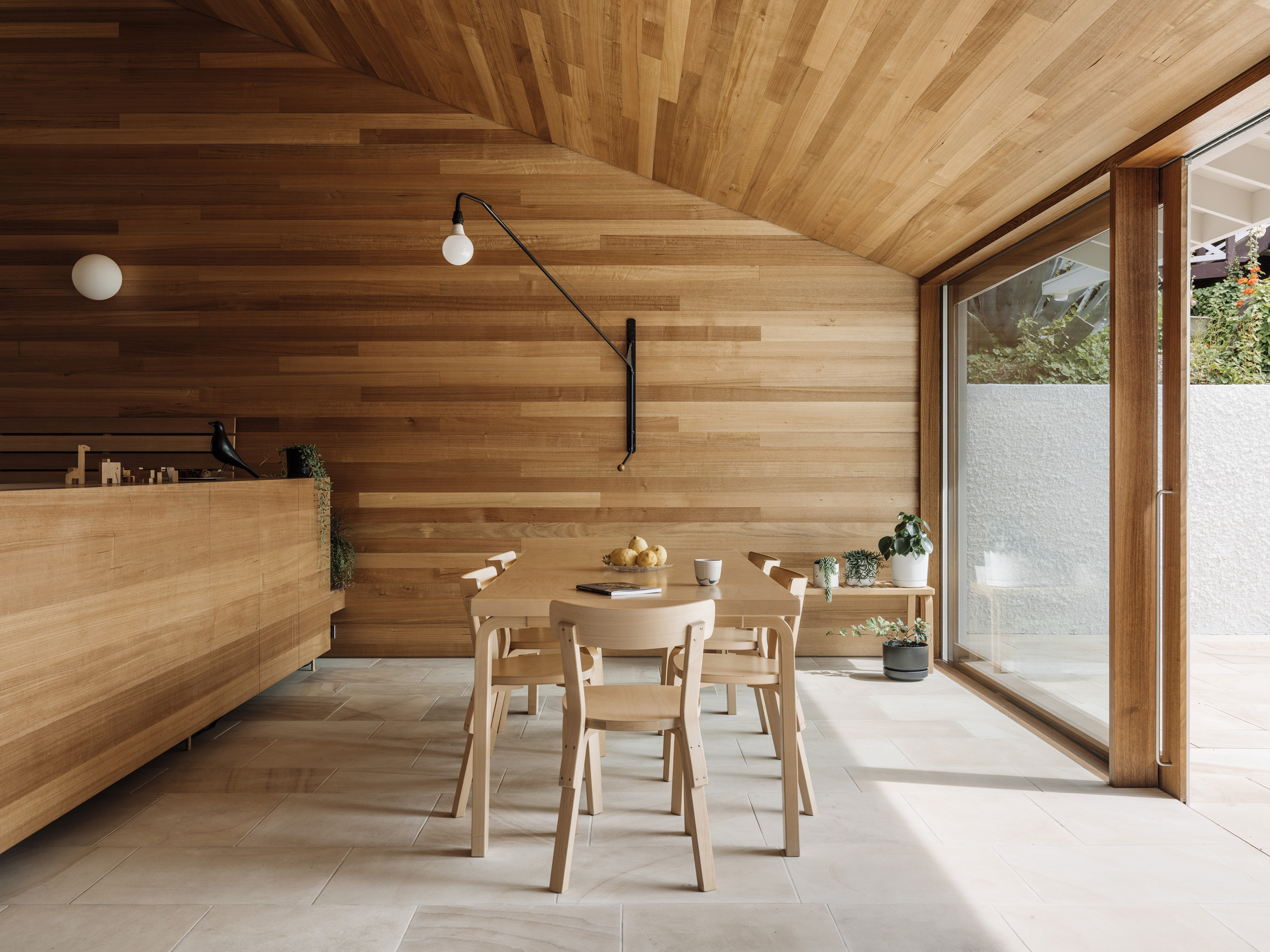 a dining table and chairs in a room with a glass wall
