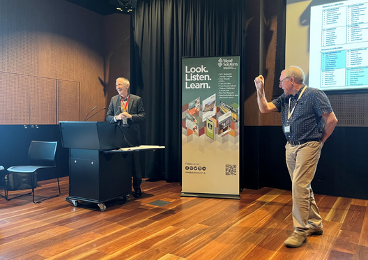 a man standing at a podium with a man in front of him
