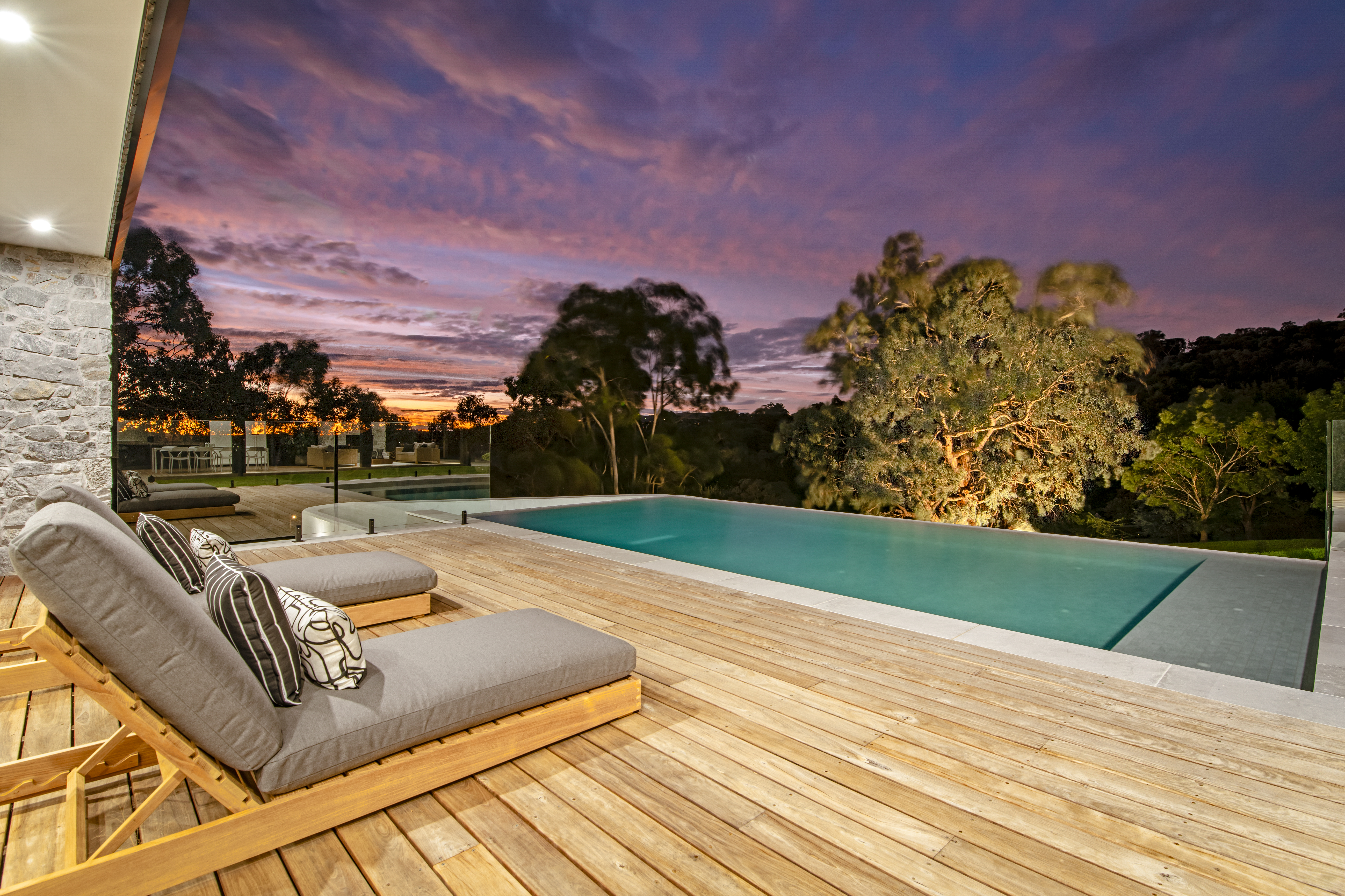 a deck with a pool and a deck with a couch and a bench