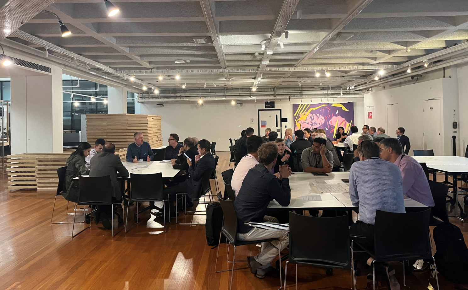Group of people in a workshop sitting at tables chatting