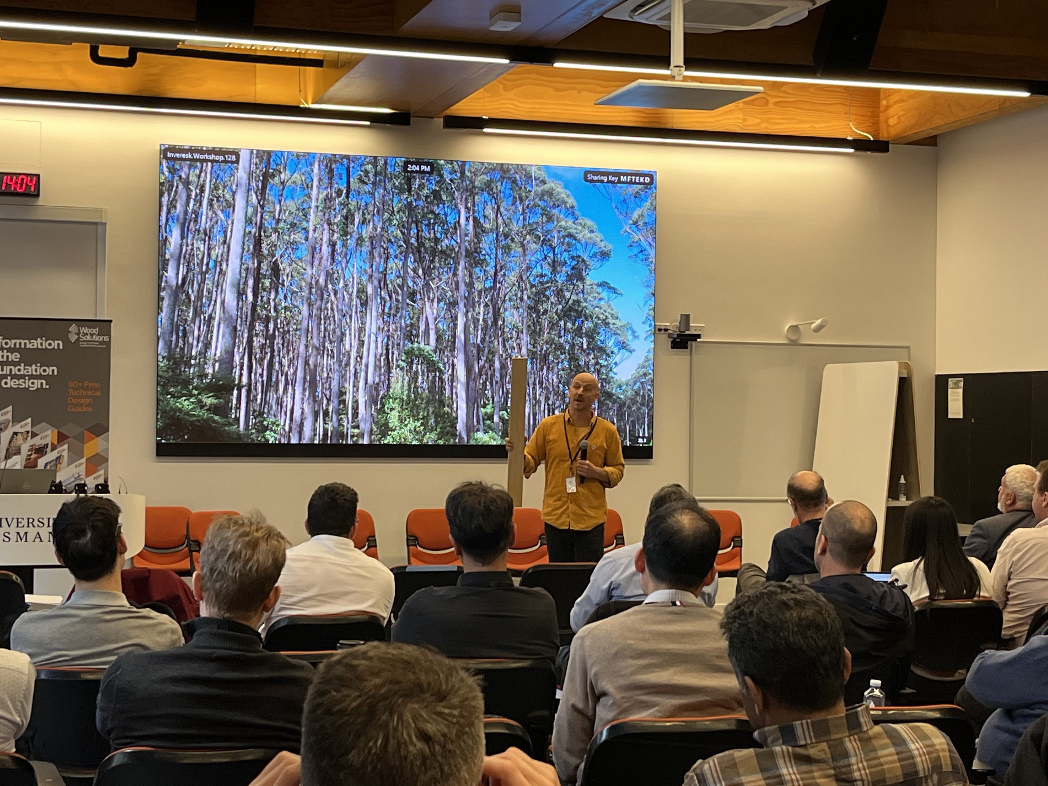 Man holding piece of timber and presenting about trees