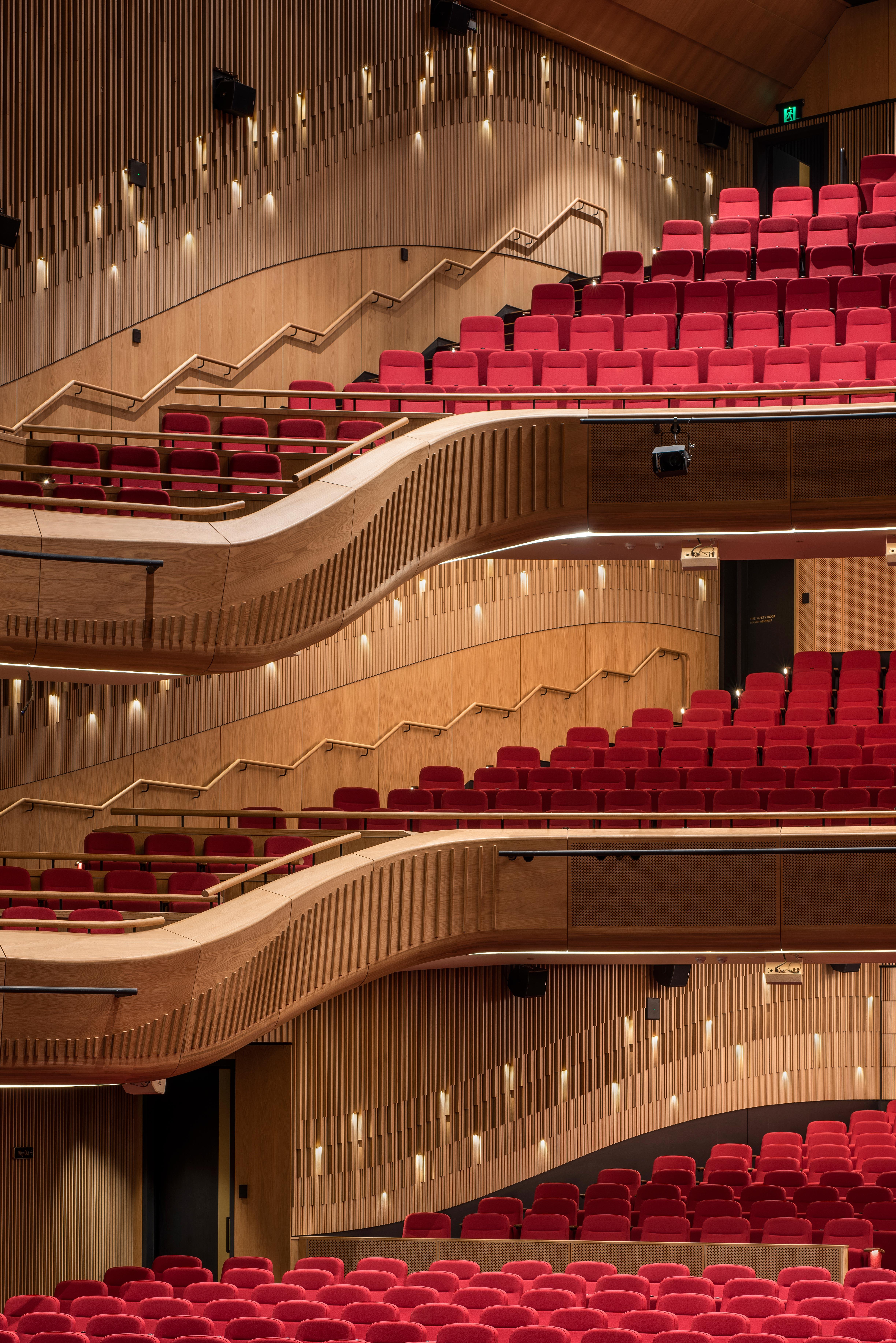 a rows of red seats in a theater