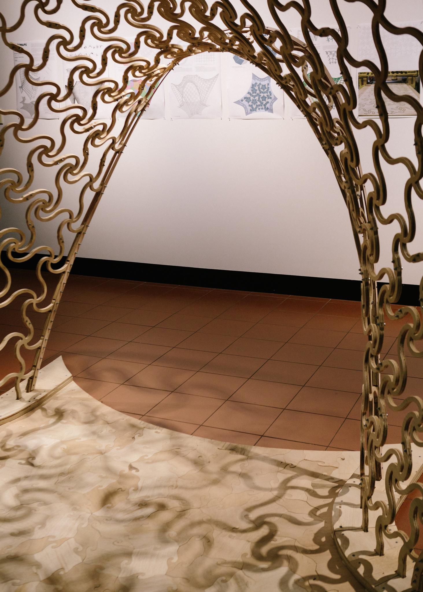 a gold gate with a white wall and a tile floor