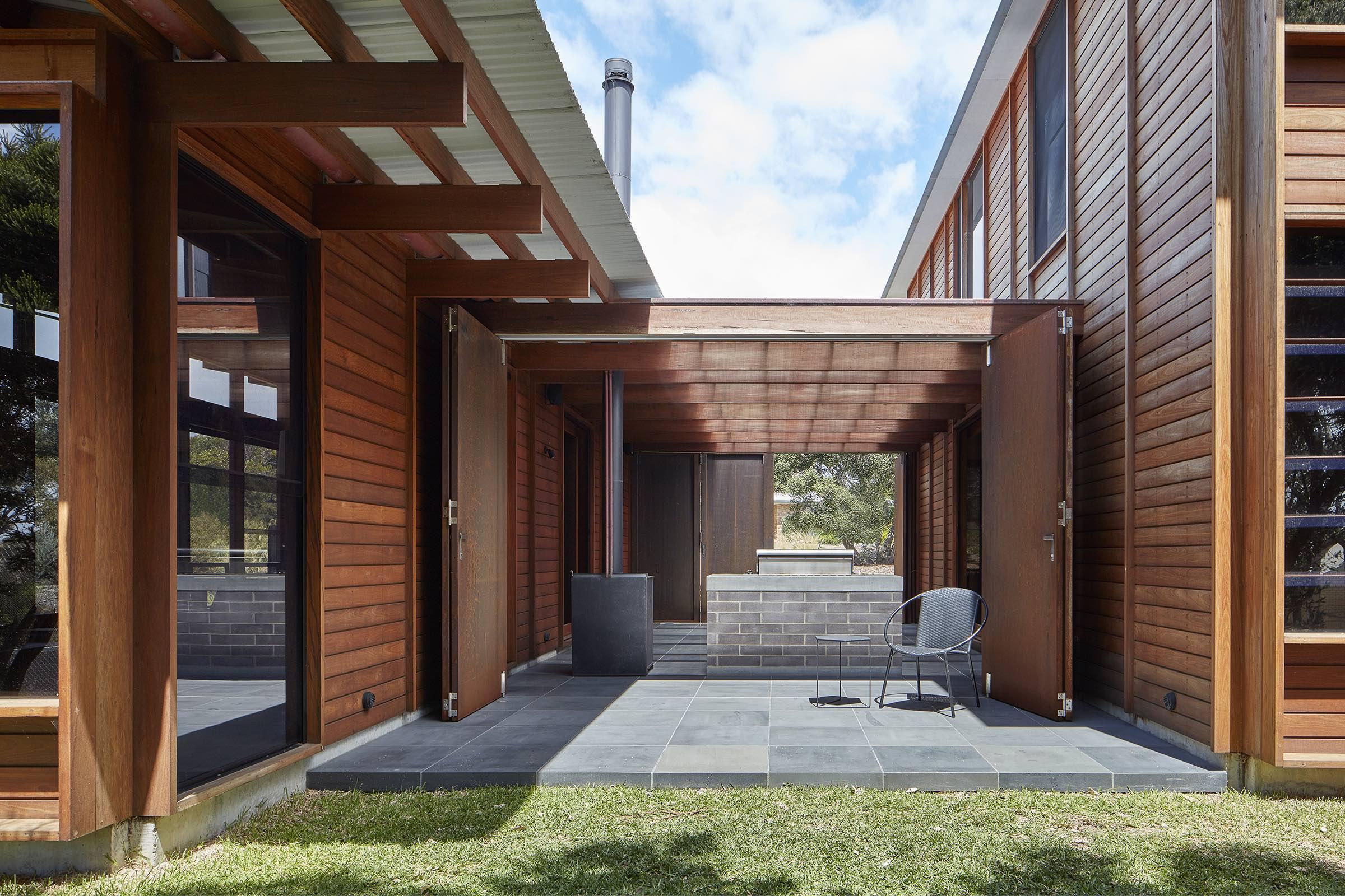 a patio with a chair and a brick fireplace