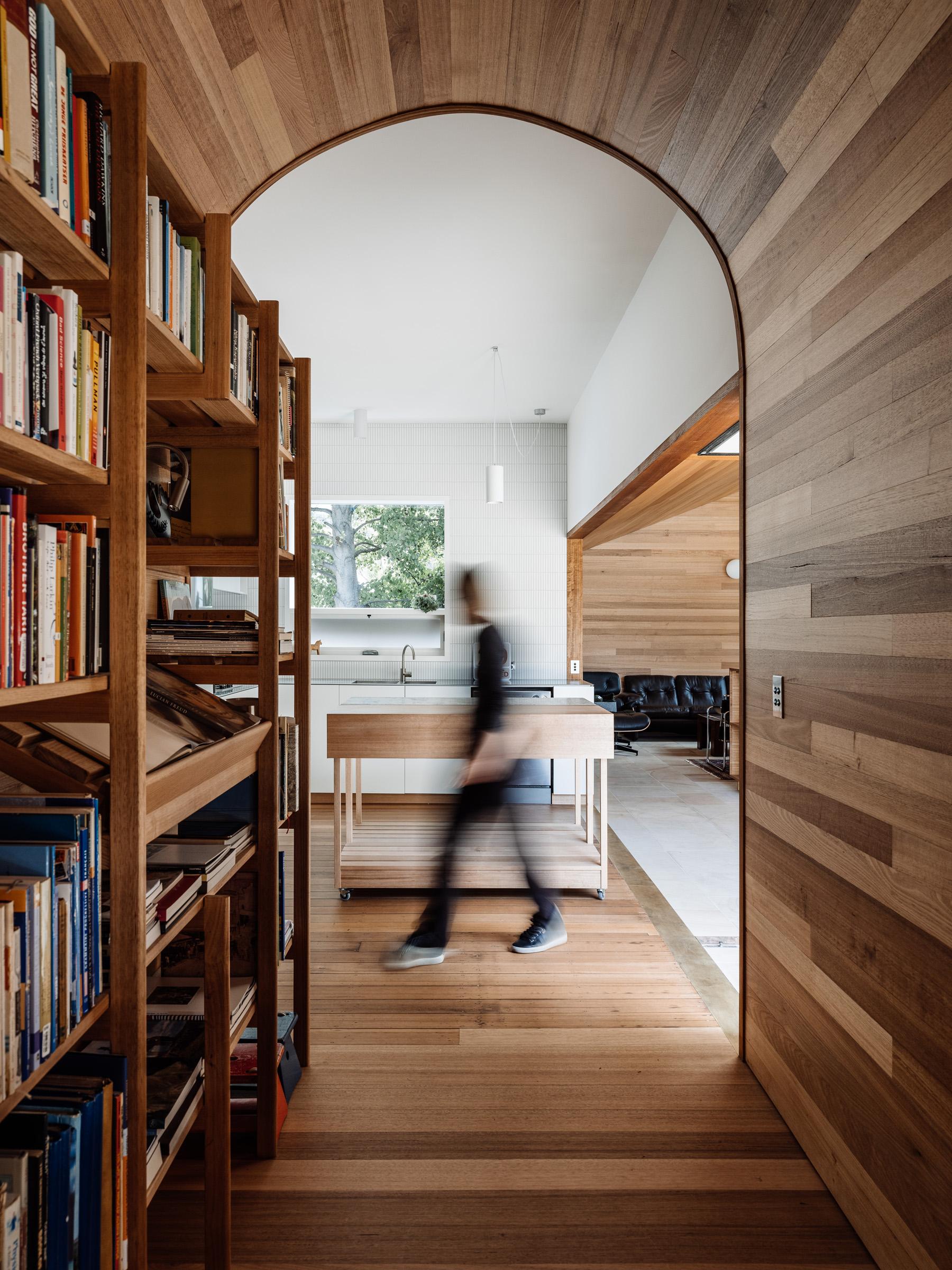 a person walking in a room with bookshelves