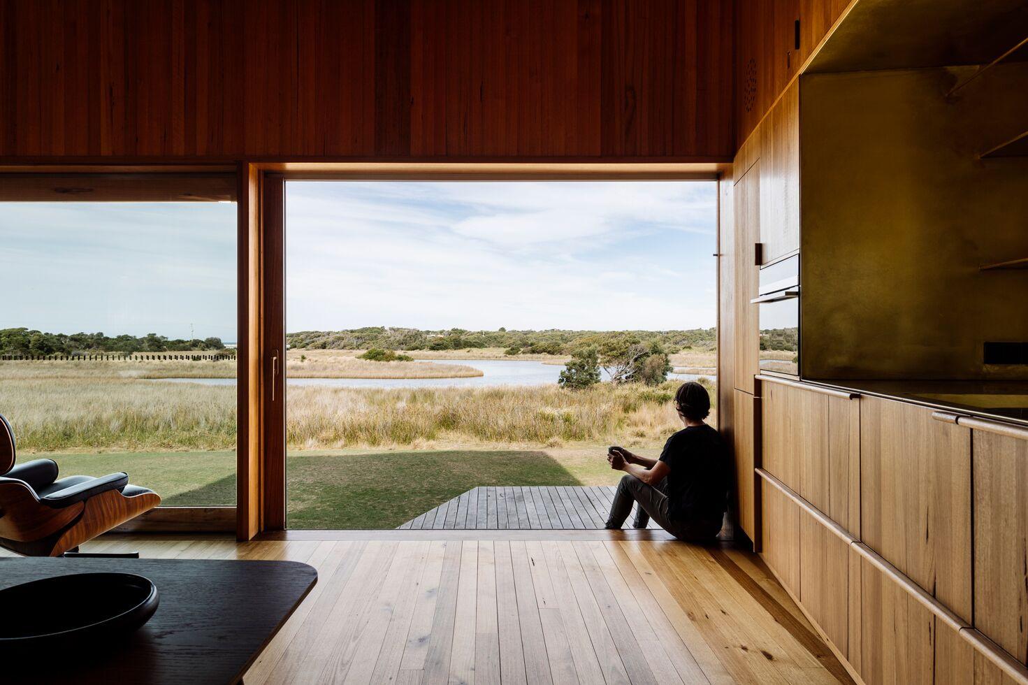 a person sitting on the floor looking out the window