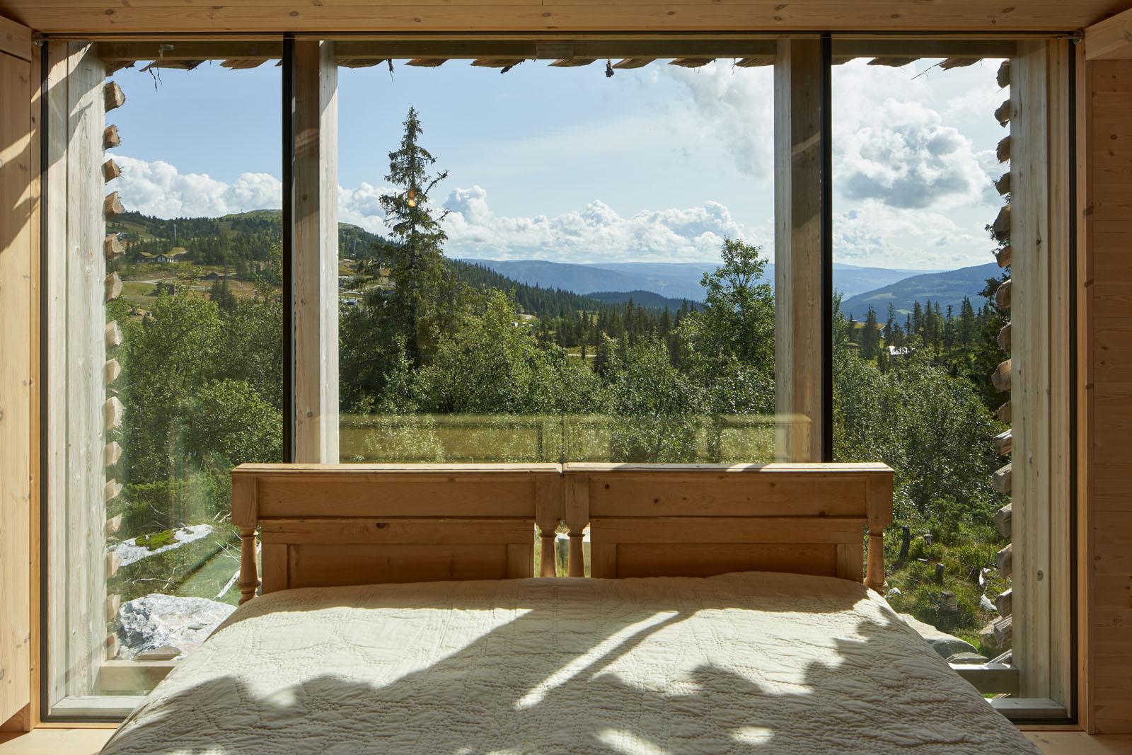 a bed with a view of trees and mountains