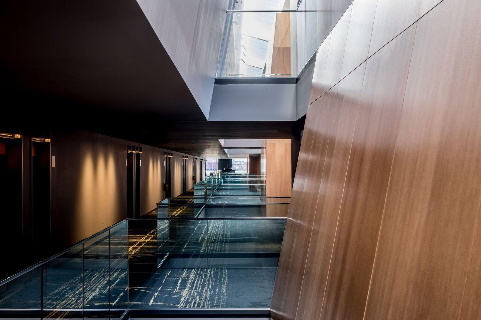 a hallway with glass railings and a glass wall