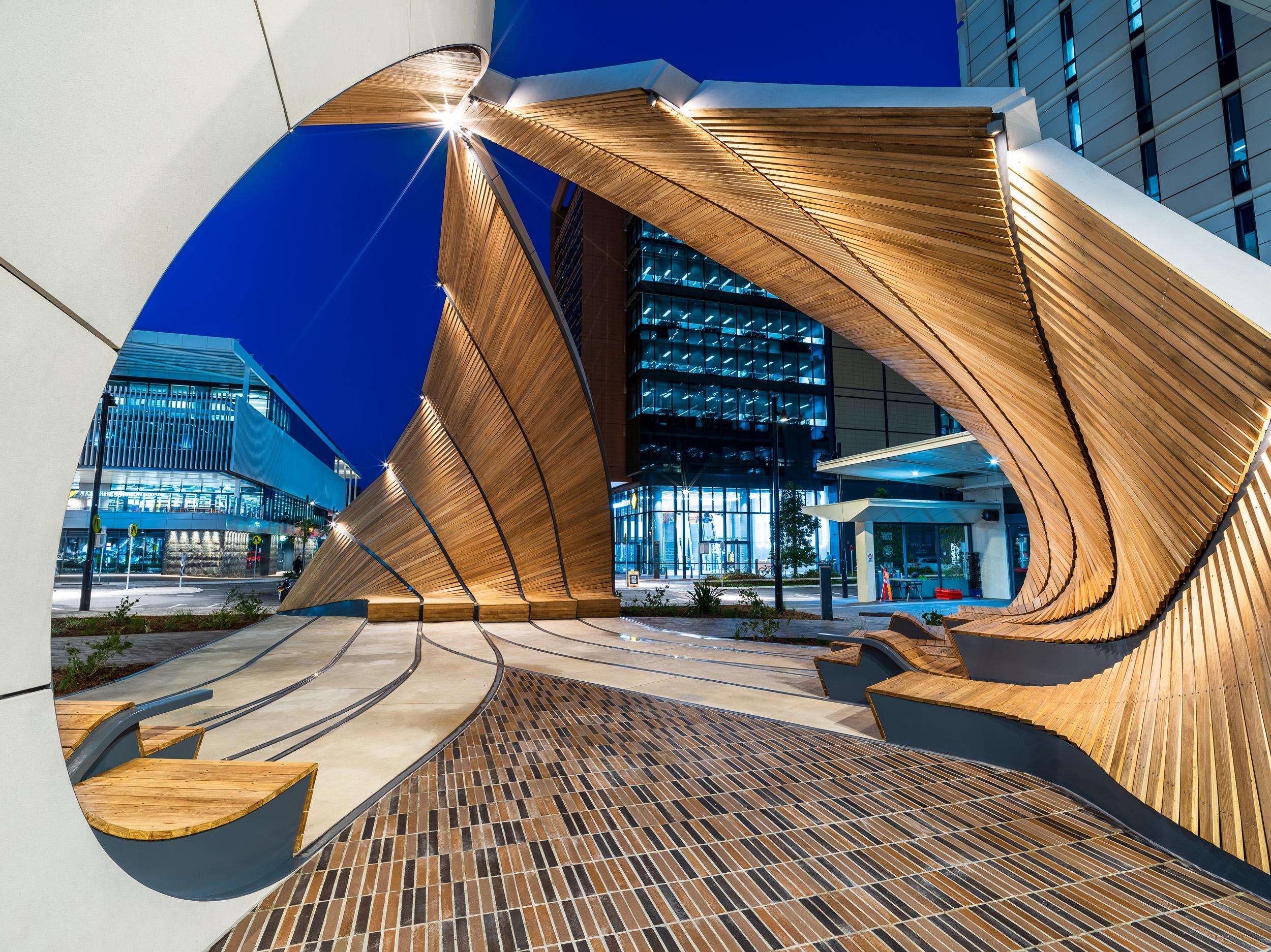 a structure with a curved structure and a brick walkway