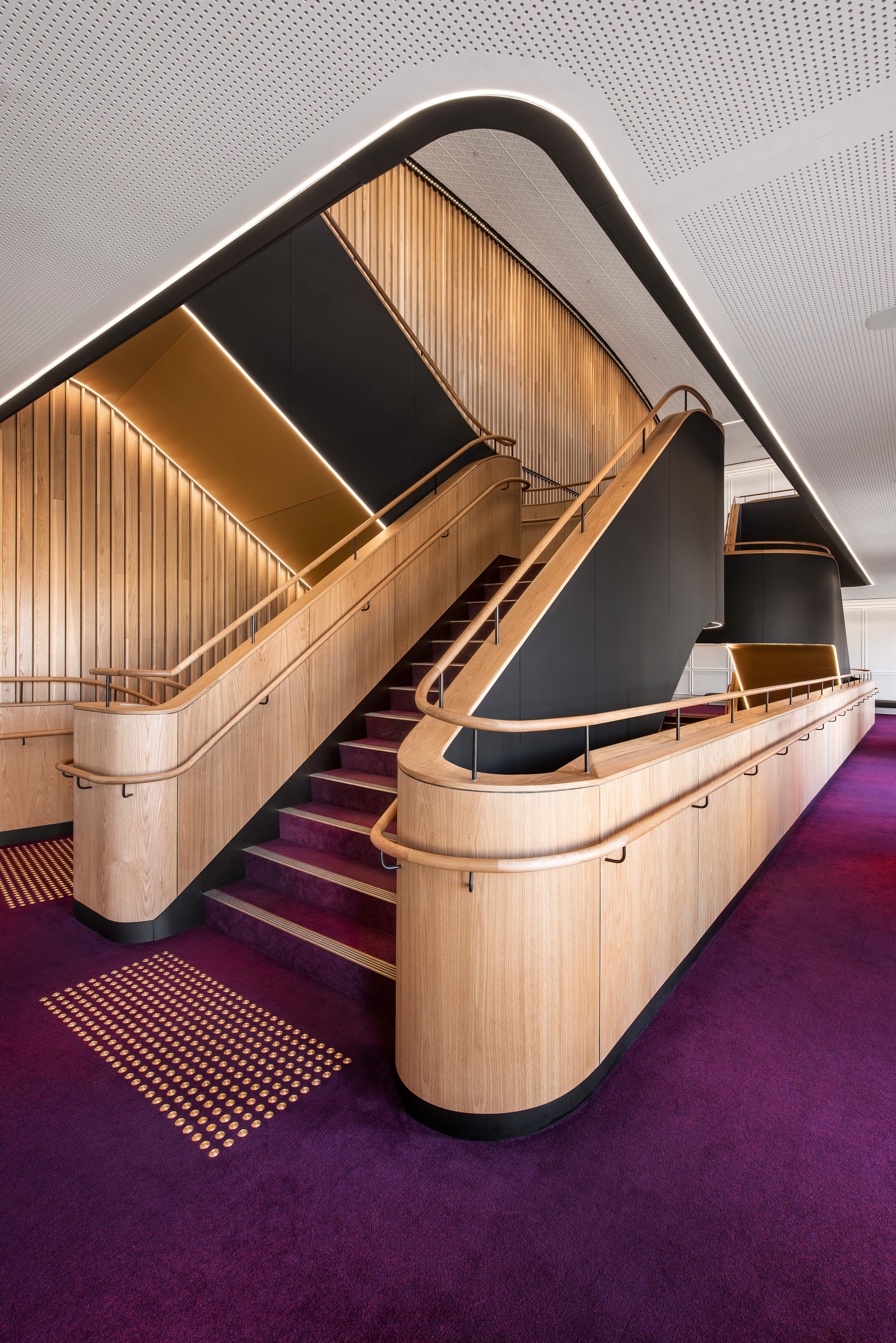 a staircase with purple carpet and wooden railings