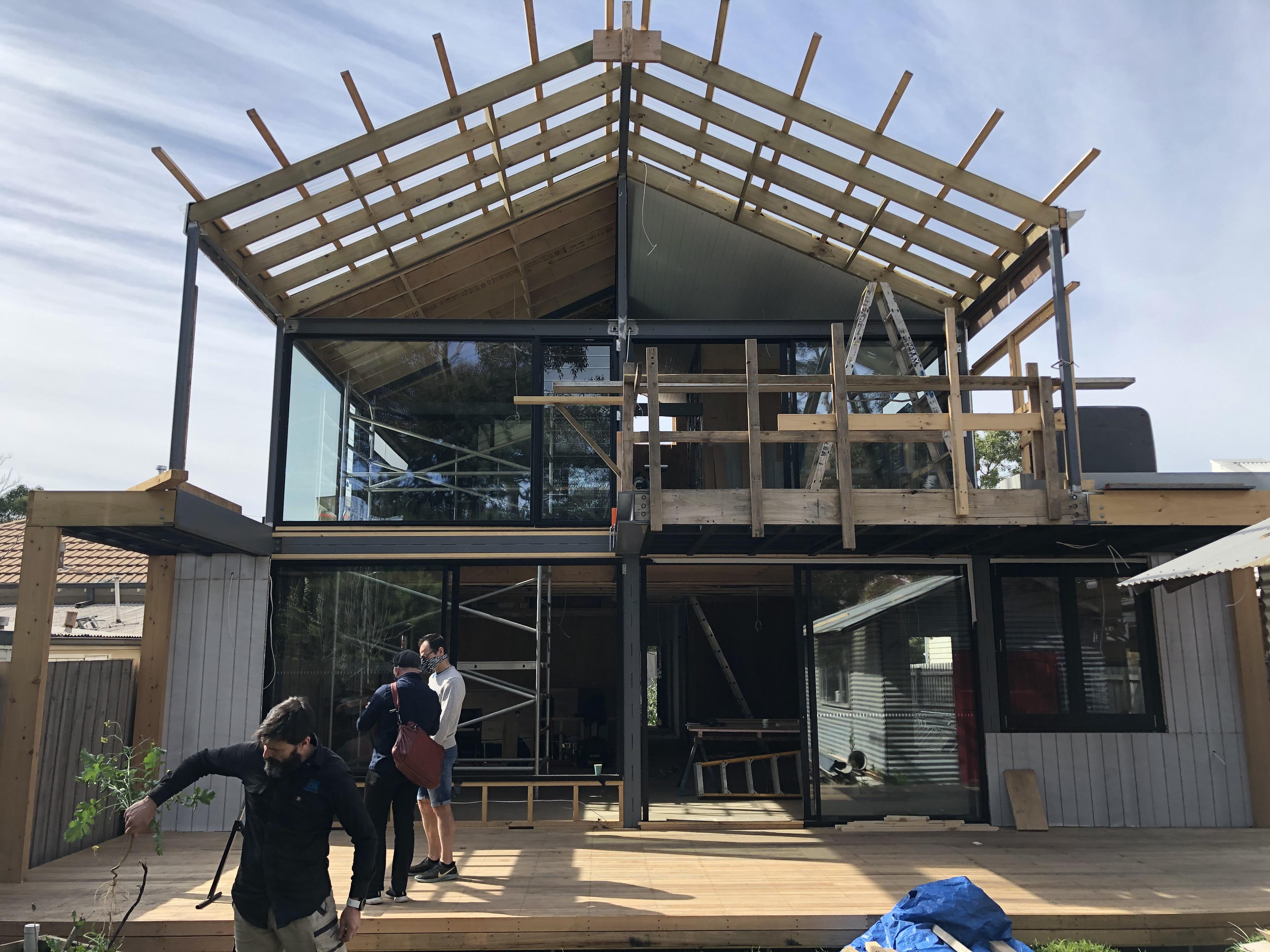 a building under construction with people standing on a deck