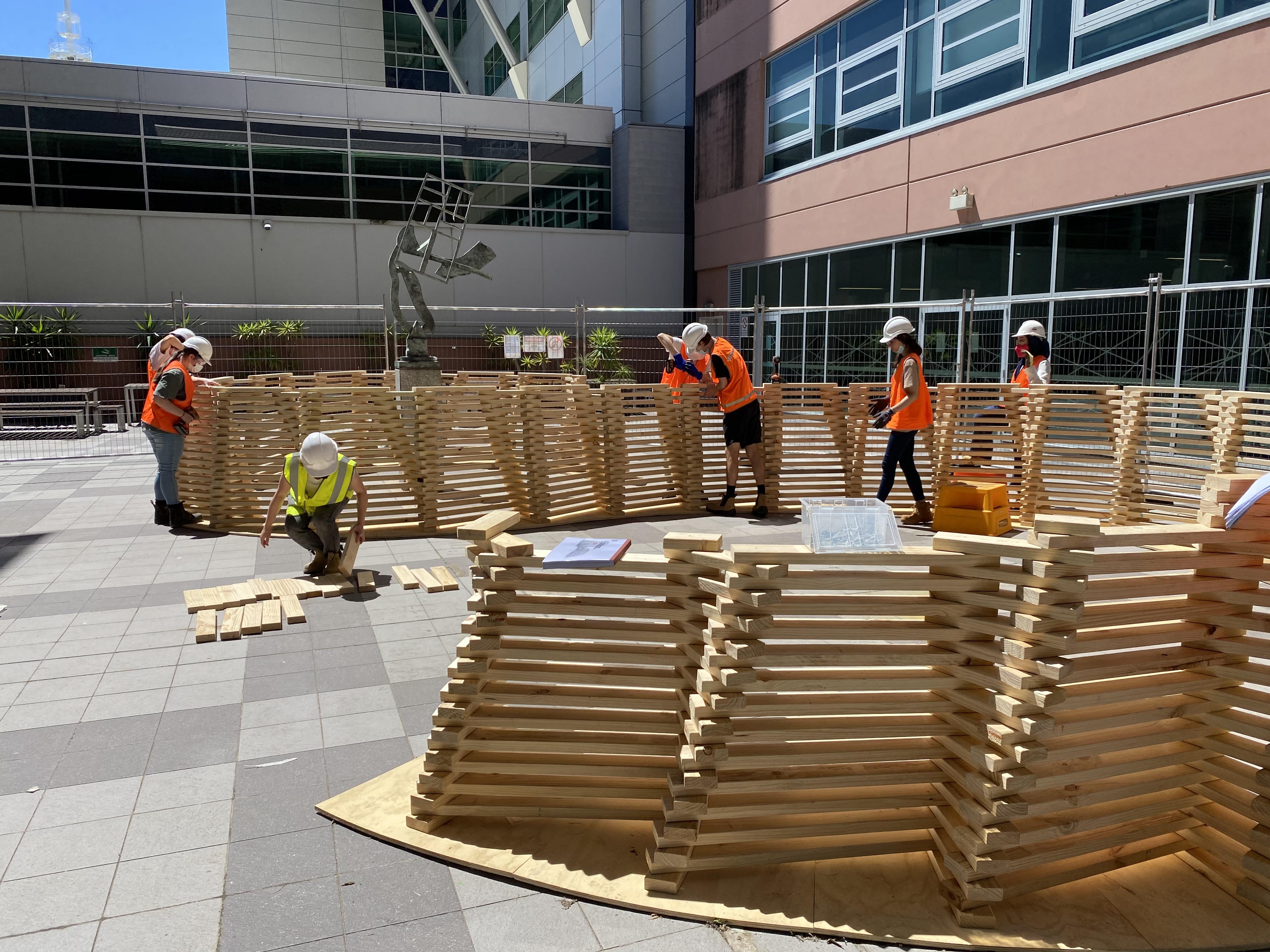 a group of people in orange vests and helmets working on a construction site