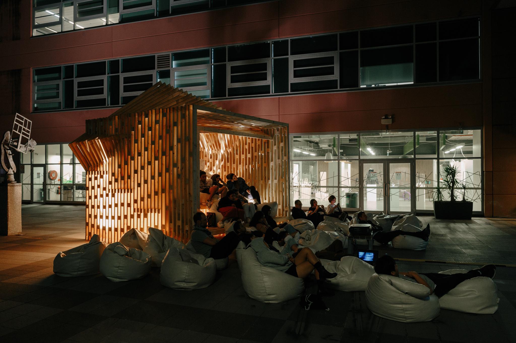 a group of people sitting in bean bags outside a building