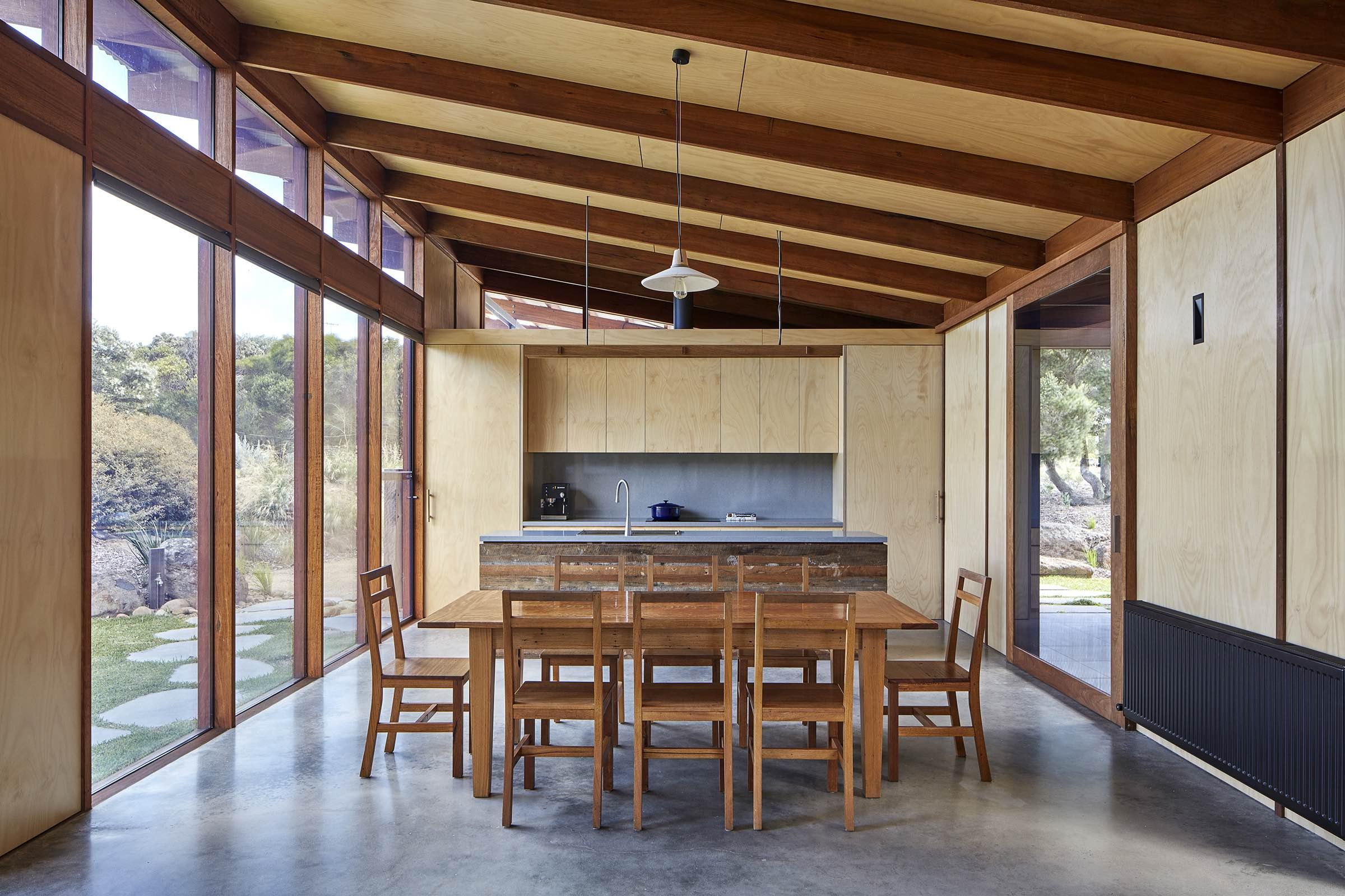a dining table and chairs in a room with glass walls
