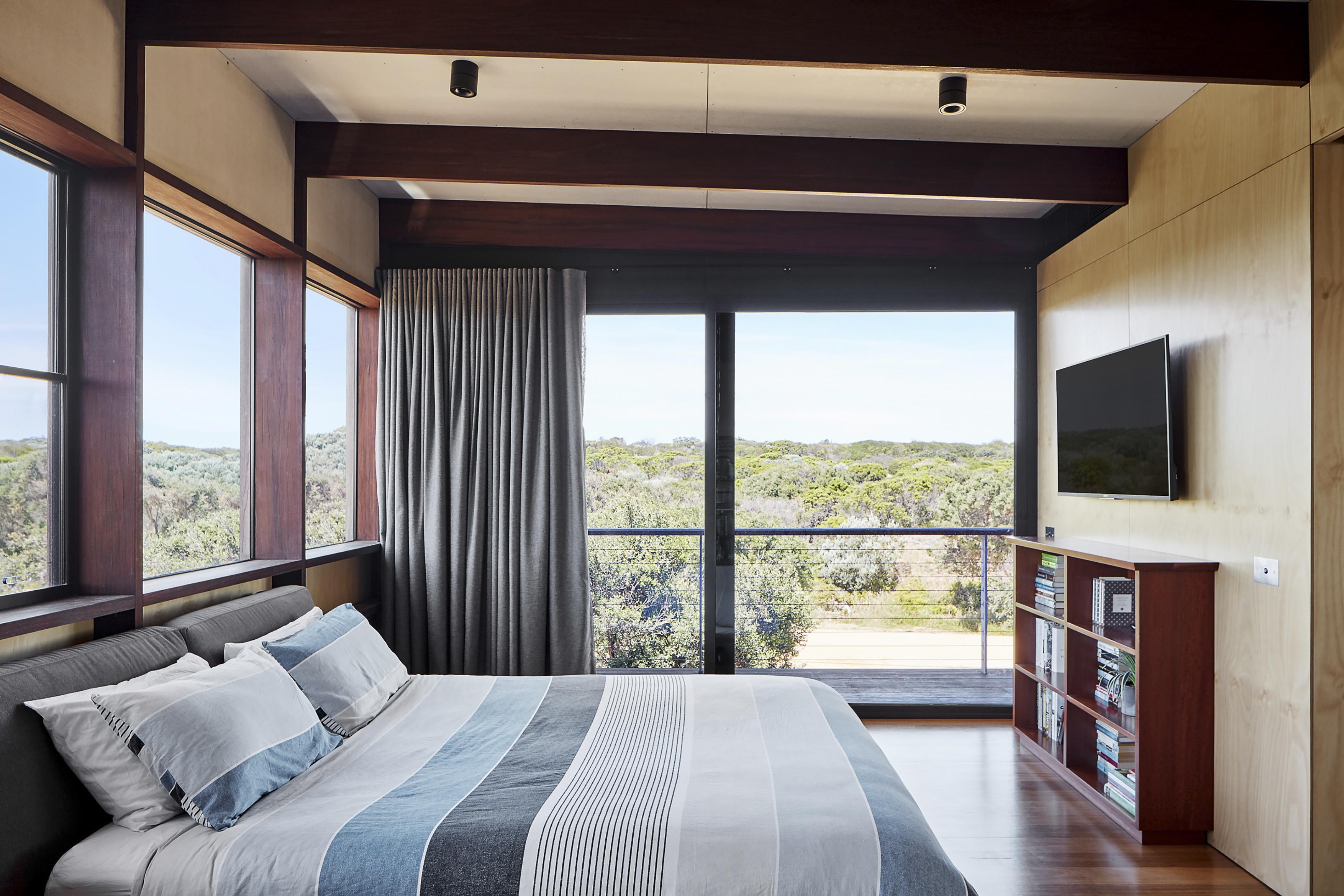 a bedroom with a large window and a large bed