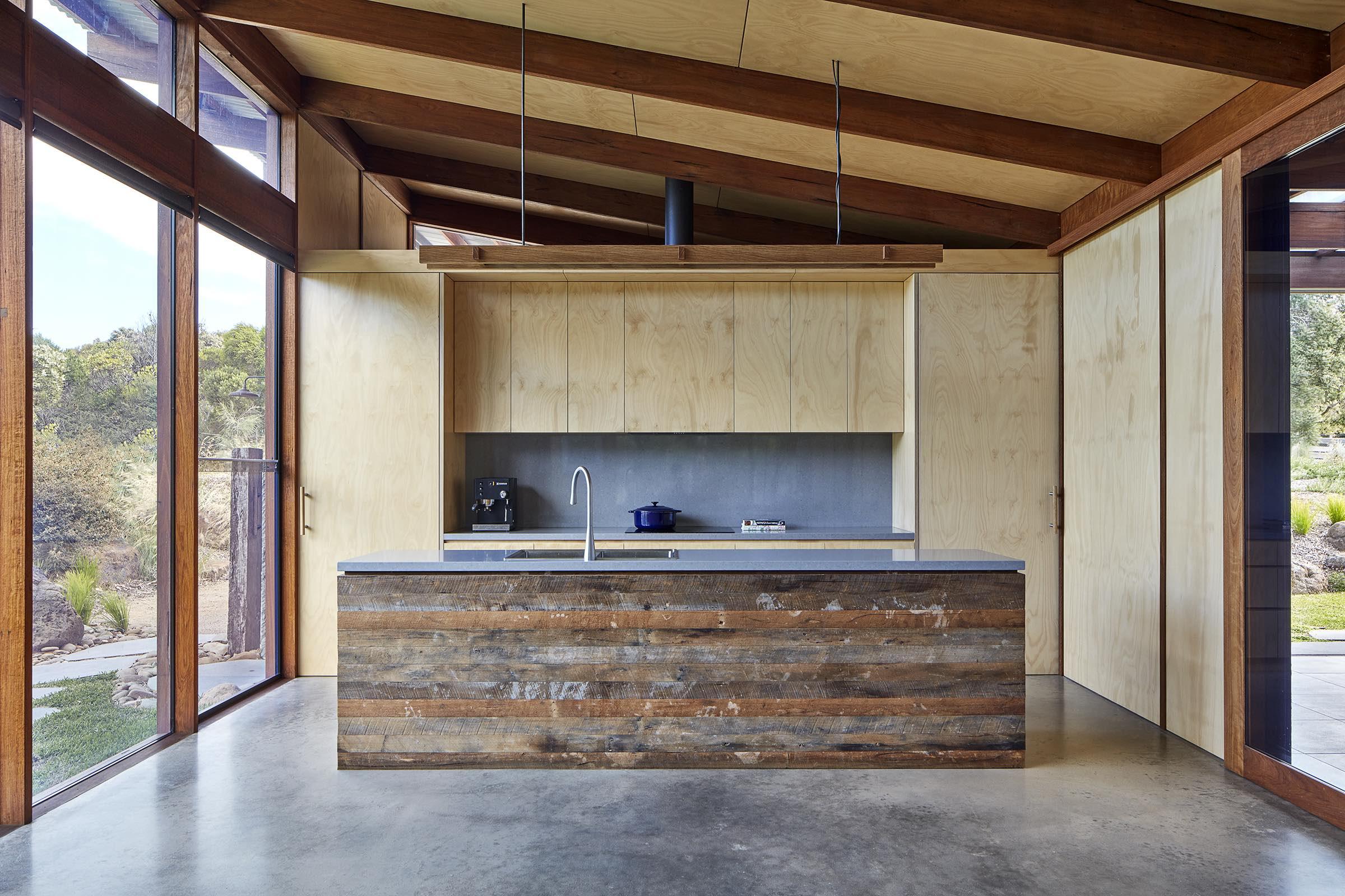 a kitchen with a wood island and a large window