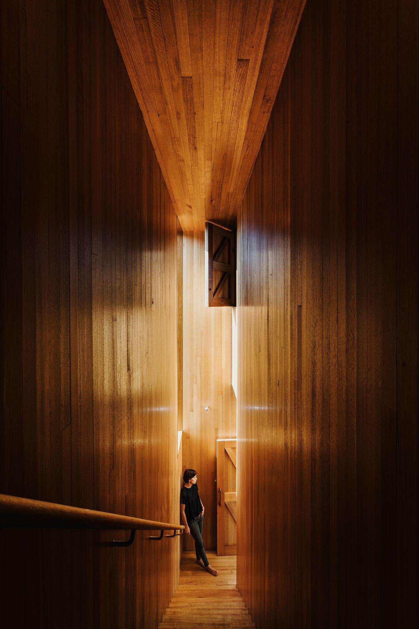 a person standing in a room with a light coming through the walls