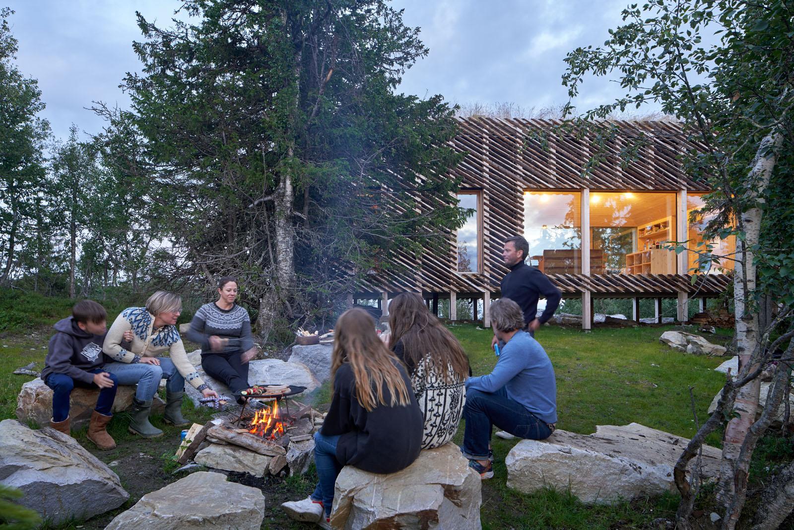 a group of people sitting around a fire in front of a building