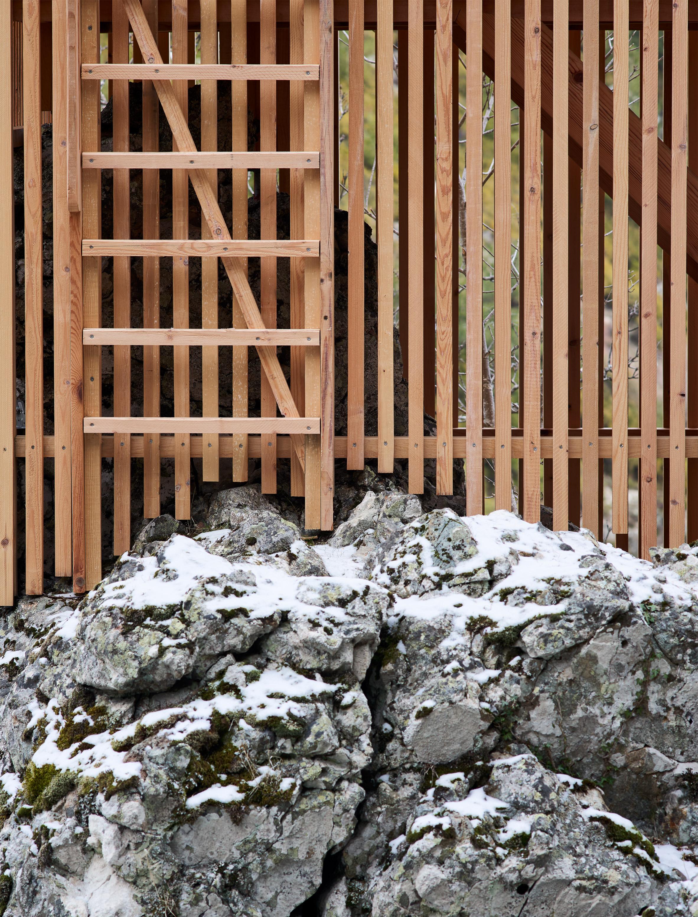a wooden fence next to a rock