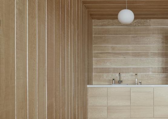 a bathroom with wood walls and a white light fixture