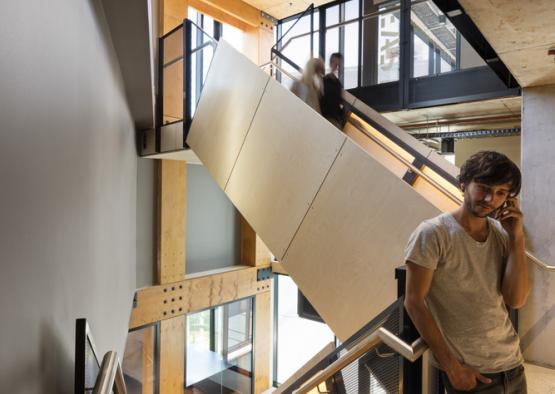 a man standing on a metal handrail in a building