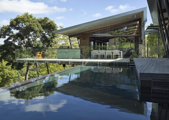 a pool with a glass roof and a building with a glass wall