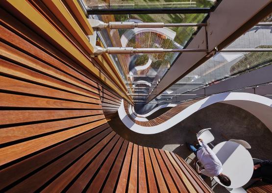 a curved staircase with a person sitting at the table