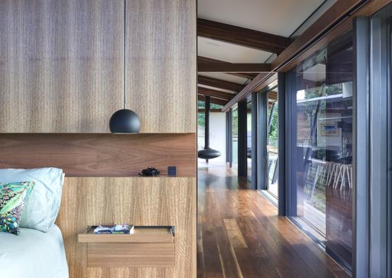 a bedroom with wood paneling and wood floor