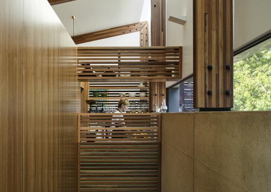 a woman standing in a room with a wooden railing