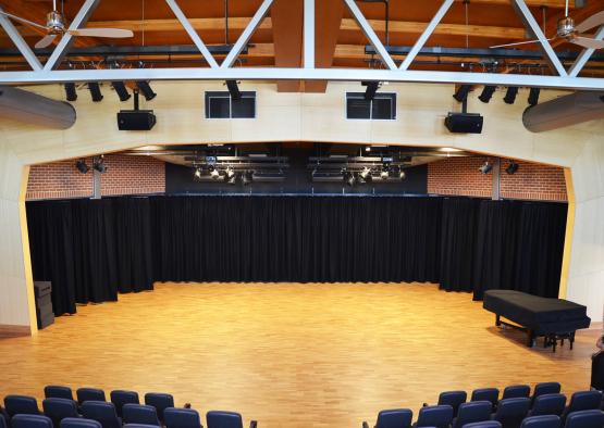 a stage with black curtains and a wooden floor