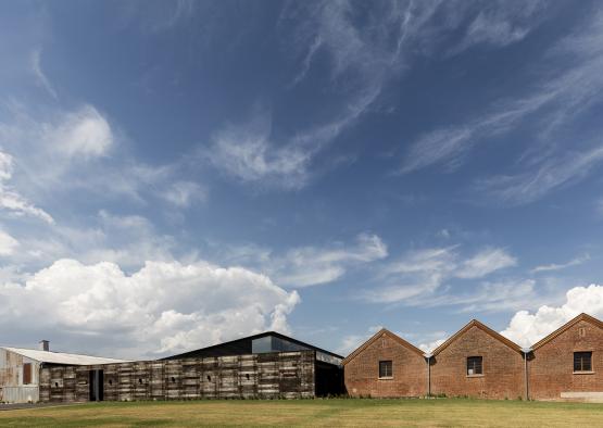 a building with a brick wall and a brick building in the background