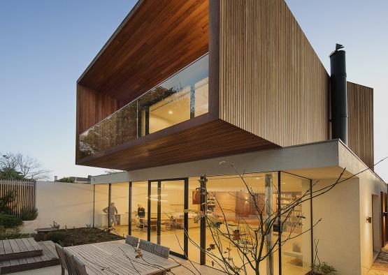 a house with a glass wall and a patio