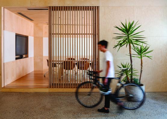 a man walking with a bicycle in a room