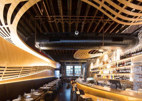 a restaurant with a bar and shelves of wine bottles