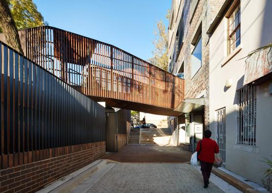 a person walking down a walkway between buildings