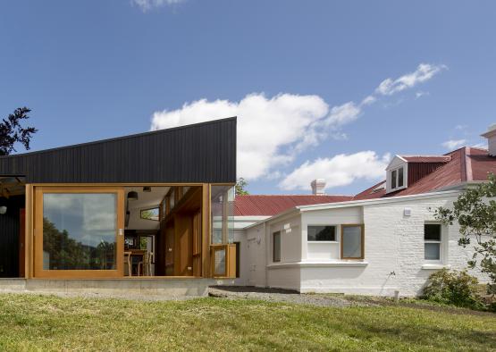 a house with a glass wall and a white brick building