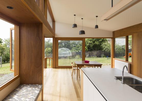 a kitchen and dining area with glass walls and a table