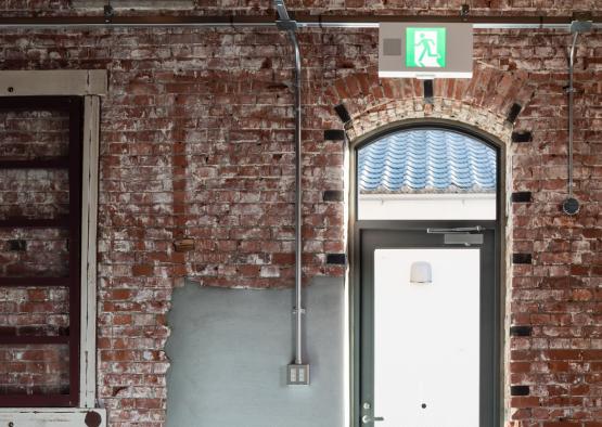 a brick wall with a green sign