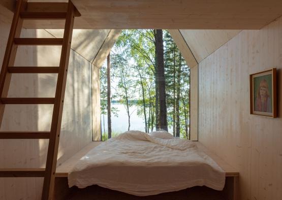 a bed in a room with a ladder and trees