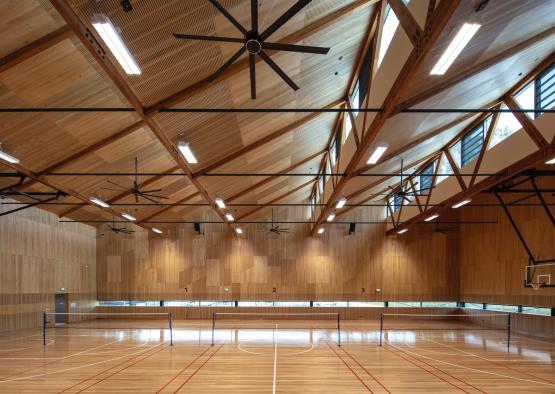 a indoor gym with a basketball court and a ceiling fan