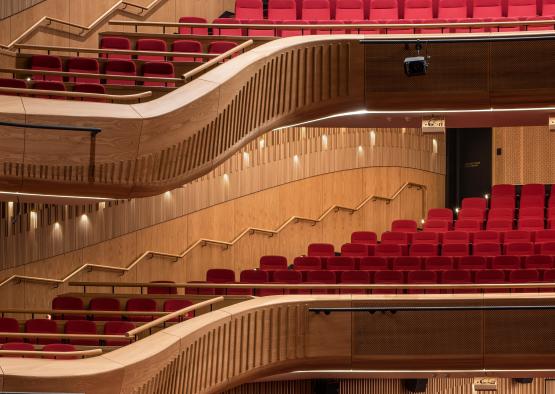 a rows of red seats in a theater