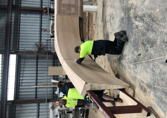 a group of men working on a piece of wood