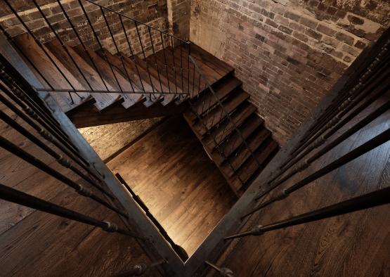 a staircase with metal railings and brick walls